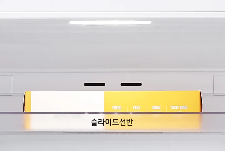 냉장고 내부 선반에 노란색과 흰색 상자가 놓여 있으며, 상자에는 FRESH, EASY, QUICK, TASTE GOOD라는 문구가 적혀 있습니다. 선반에는 슬라이드선반이라는 문구가 있습니다.